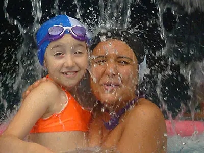 Enfant et adulte sous une cascade d'eau